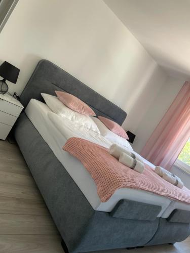 um quarto com uma cama cinzenta com almofadas em Apartment Tomy em Rijeka