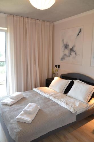 1 dormitorio con 1 cama grande y 2 toallas. en Apartament Młynówka, en Gdansk