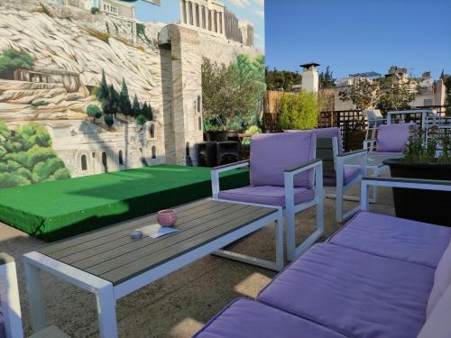 a patio with two chairs and a green lawn at Be My Guest Athens in Athens