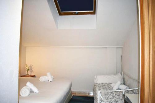 a small room with two beds and a tv at Hotel El Ancla in Villanueva de la Cañada