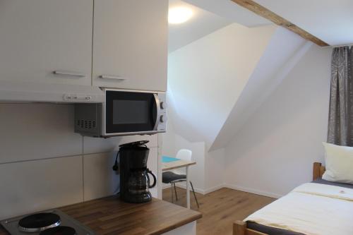 Habitación pequeña con cama y TV. en Pension König en Kassel