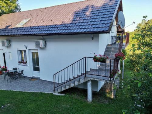 a white house with a staircase and a patio at New apartment near Plitvice lakes in Smoljanac