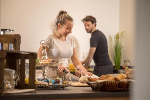 Ein Mann und eine Frau stehen in einer Küche und bereiten Essen vor in der Unterkunft Landhotel Weihermühle in Thaleischweiler-Fröschen