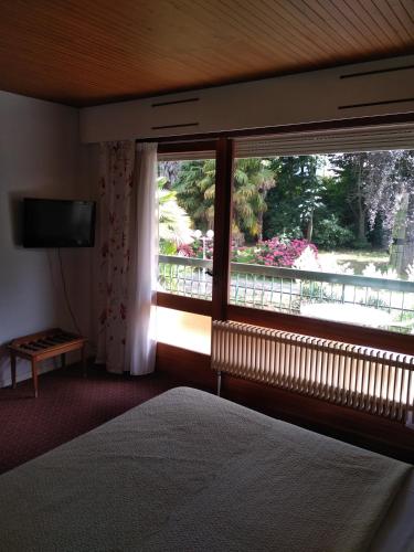 sypialnia z łóżkiem i oknem z widokiem w obiekcie Hotel Le Mas Fleuri w mieście Vernet-les-Bains