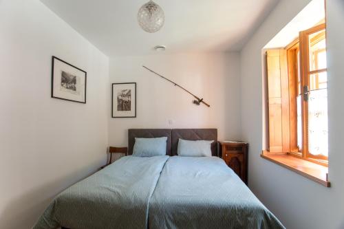 a bedroom with a bed and a window at Apartmaji Utrinek, apartma Salon in Podbrdo