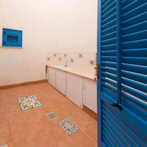 a bathroom with a blue door and a sink at Appartamenti Praya in Favignana