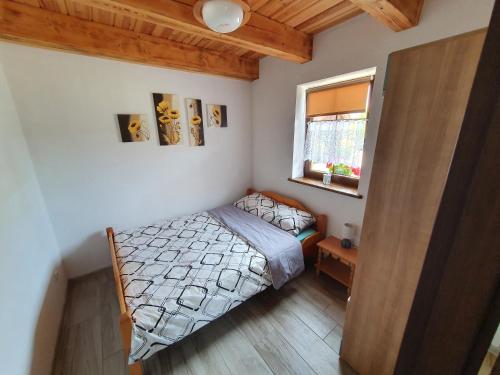 niewielka sypialnia z łóżkiem i oknem w obiekcie Gościniec Gałkowo w mieście Gałkowo