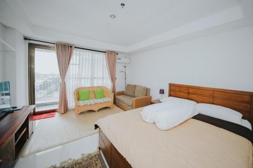 una camera con un letto e una sedia e una finestra di Apartemen Tera Residence a Bandung