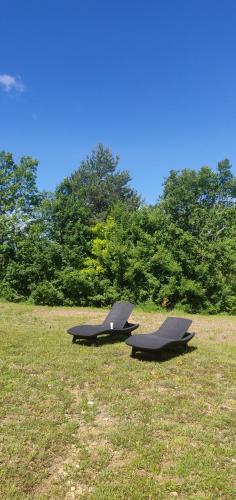 two picnic tables sitting in a field of grass at Chez Fanny - Les Tuileries - Gîte 1-4 pers. avec jardin privatif - proche Cahors in Le Montat