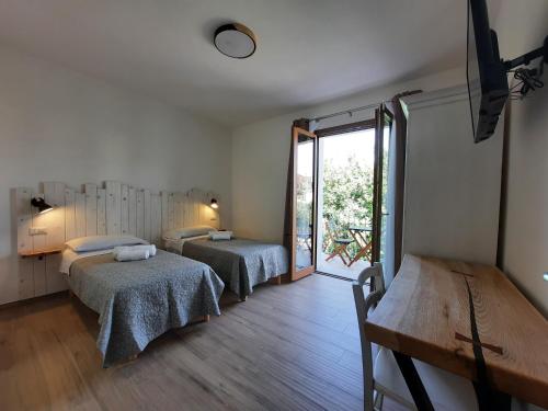 sypialnia z 2 łóżkami i dużym oknem w obiekcie Affittacamere Su Maistu e Linna w mieście Cardedu