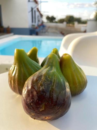 a group of green peppers on a table next to a pool at Monte do Pombal in Sousel