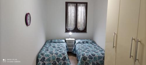 Zimmer mit 2 Betten und einem Fenster in der Unterkunft Casa di Lu in SantʼAntìoco
