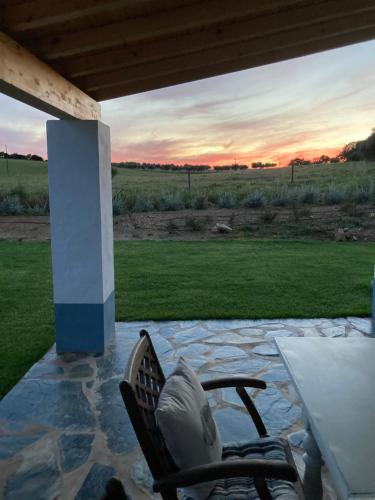a patio with a table and a chair on a stone patio at Monte do Pombal in Sousel
