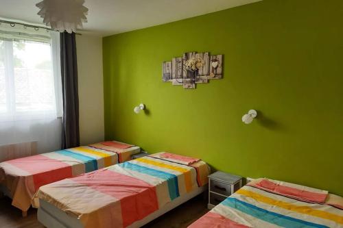 duas camas num quarto com paredes verdes em Les gîtes de la commanderie de Saint Jean MONTET em Beynat