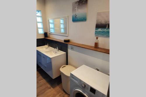 uma casa de banho com um lavatório, um WC e uma máquina de lavar roupa em Les gîtes de la commanderie de Saint Jean MONTET em Beynat