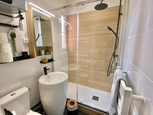 a bathroom with a shower and a toilet and a sink at We Sea in Deauville