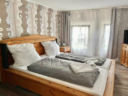 a bedroom with a large bed with a wooden headboard at The Burgklause Boutique Hotel in Linz am Rhein