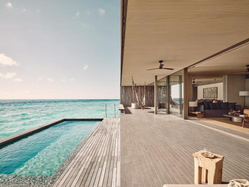 a house on the beach with a swimming pool at Patina Maldives, Fari Islands in North Male Atoll