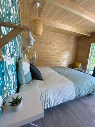 um quarto com uma cama num quarto de madeira em Moulin Room em Naours