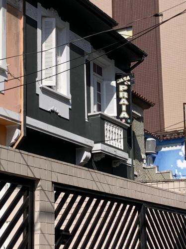 un edificio blanco y negro con un letrero. en Casa da Praia en Santos