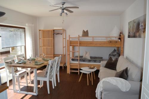 ein Wohnzimmer mit einem Sofa, einem Tisch und einem Etagenbett in der Unterkunft Ferienwohnung Gruber in Tumpen