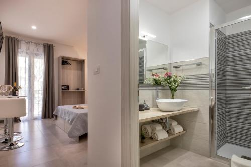 a white bathroom with a sink and a shower at Atteros in Alghero