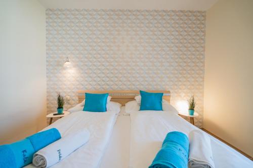 a bedroom with two beds with blue pillows at Villa Frida in Siófok