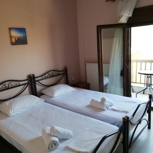 two twin beds in a room with a mirror at P.A.G Apartments in Nea Roda