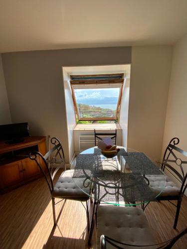 une table et des chaises dans une pièce avec une fenêtre dans l'établissement La perle marine, à Trouville-sur-Mer