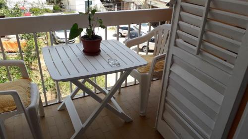 a table and chairs on a balcony with a potted plant at Guesthouse Ljilja - apartment with balcony 2 in Meljine
