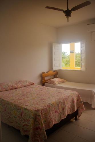 Pousada Pau Brasil في إلها دي كومانداتوبا: غرفة نوم بسريرين ونافذة