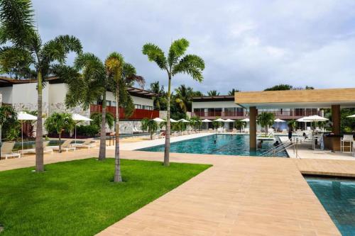 a swimming pool with palm trees and a resort at ILE DE PIPA LUXO in Pipa