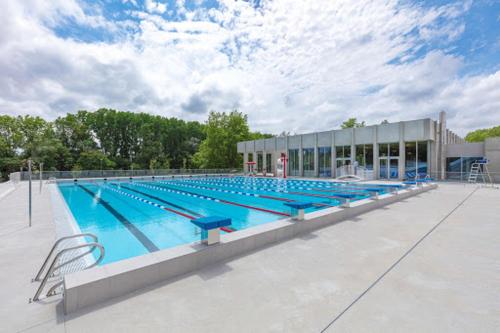 une grande piscine devant un immeuble dans l'établissement La Maisonnette, à Carcassonne