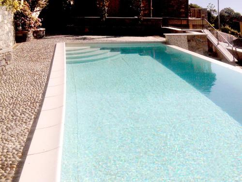 a swimming pool with blue water in a yard at Residence Giglio Comer See in Gravedona