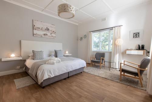 a bedroom with a bed and two chairs and a window at Ballinderry, The Robertson Guest House in Robertson