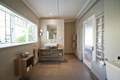uma casa de banho com um lavatório e um espelho em Ballinderry, The Robertson Guest House em Robertson