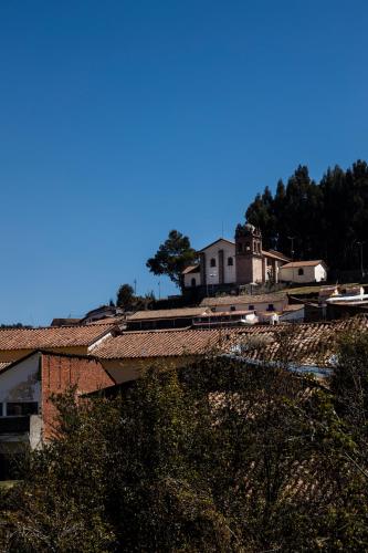 a house sitting on top of a hill with houses at Hostal & Apartments El Triunfo in Cusco