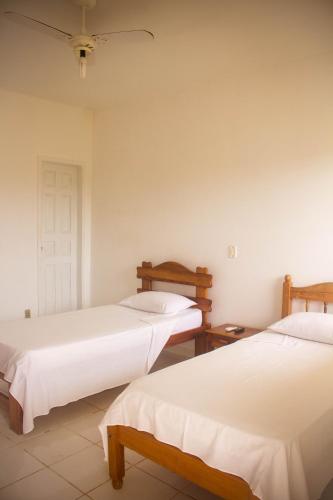 a bedroom with two beds and a ceiling at Pousada Pau Brasil in Ilha de Comandatuba