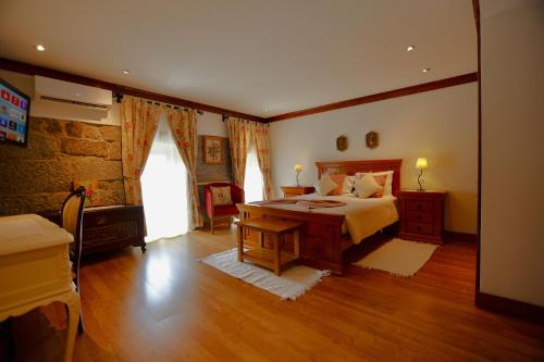 a large bedroom with a bed and a window at Quinta de CasalMato in Resende