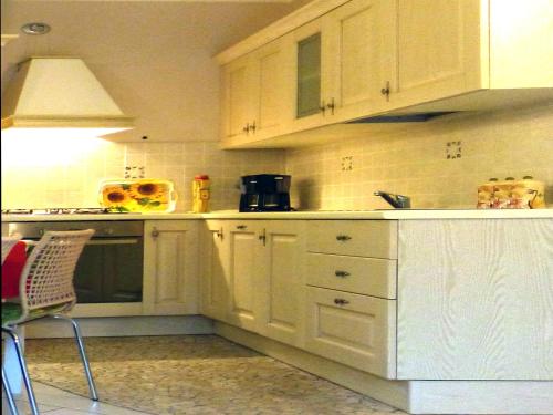 a white kitchen with white cabinets and a sink at Residence Giglio Comer See in Gravedona