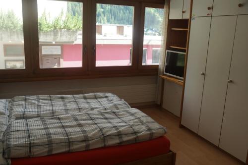 - une chambre avec un lit et une fenêtre dans l'établissement Lovely 1-bedroom apartment in the heart of Davos, à Davos