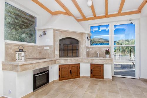 eine große Küche mit einem großen Fenster und einer Theke in der Unterkunft Villa Antonia with heated pool in Dograde