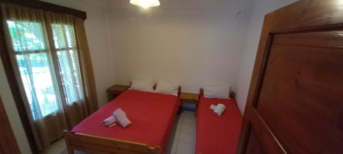 a small room with two beds and a window at Filio Rooms in Nikiti