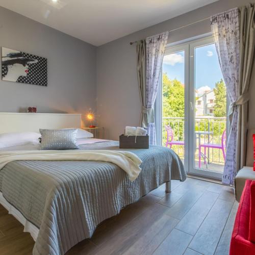 a bedroom with a bed and a large window at House Diana in Dramalj