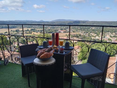 a table with a plate of food on a balcony at Lou calado in Fayence