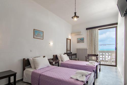 a hotel room with two beds and a balcony at Zantina in Rethymno