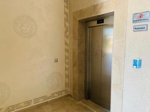 a elevator door in a building with a sign on the wall at APPARTEMENT PARADISIAQUE entre HAMMAMET et NABEUL in Nabeul