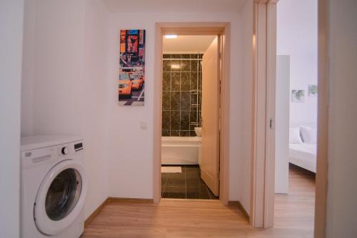 bagno con lavatrice e vasca. di Miralex - Moonlight Residence a Mamaia