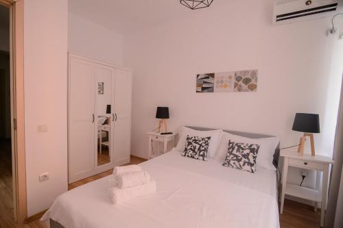 una camera bianca con letto bianco e cuscini di Miralex - Moonlight Residence a Mamaia