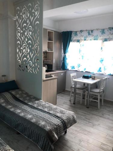 a bedroom with a bed and a table and a kitchen at Studio Turquoise - Eforie Nord in Eforie Nord